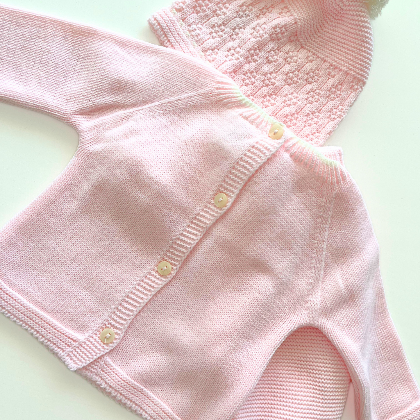 Conjunto de primera puesta de lana rosa con detalle de pompón